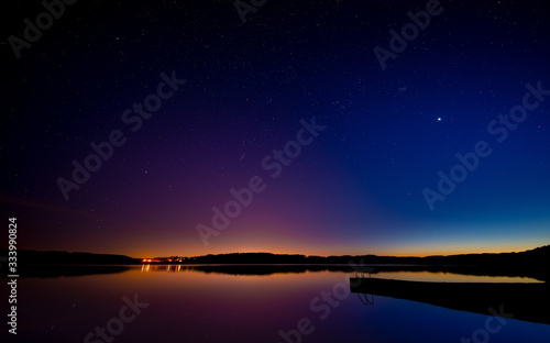 Late sunset on the lake. Beautiful night starry sky.