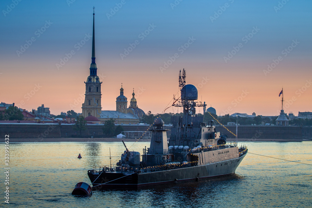 Saint Petersburg. Russia. Ship on the Neva. Rivers Of St. Petersburg. White night. Warship on the background of the Peter and Paul fortress. The vessel on the Neva is decorated with garlands.
