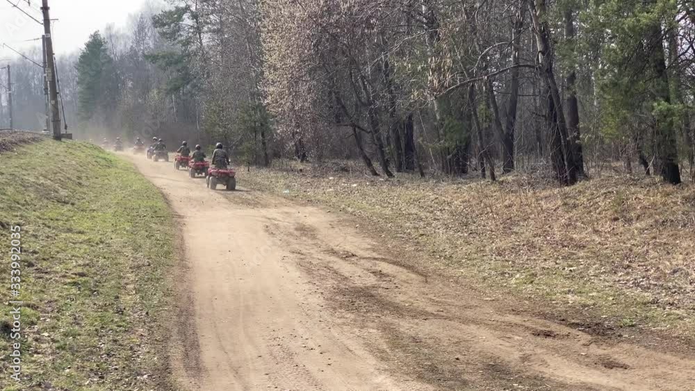 A row of ATV going on forest road A row of ATV going on forest road