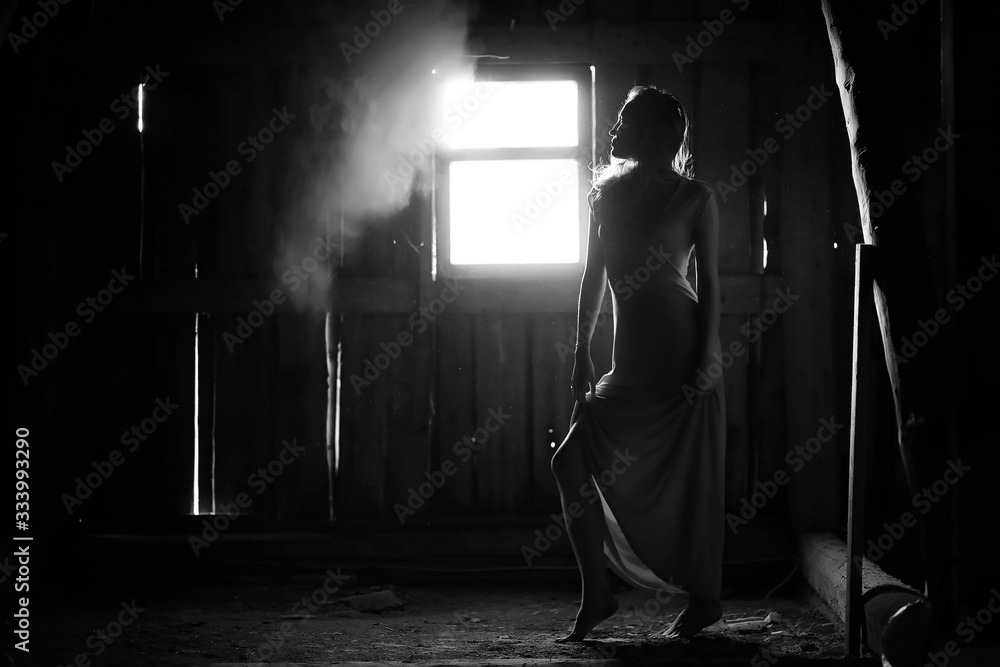 Fototapeta styl glamour. Piękna kobieta w ciemnym pokoju z oknem.