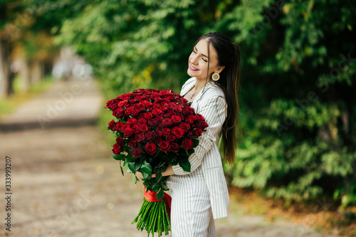 Valentines day. Woman holding bouquet of red roses. Beautiful girl received romantic present.