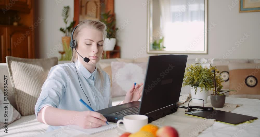 Sales representative in headset speaking to client and making video conference call on laptop. Sales representative in headset speaking to client and making video conference call on laptop.