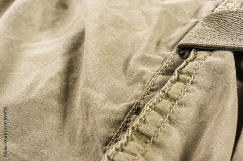 clothing items stonewashed cotton fabric texture with seams, clasps, buttons and rivets, macro