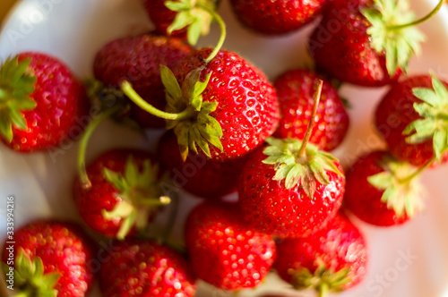 fresh ripe berries strawberries on white ceramic plate  close up