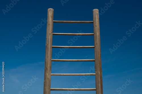 A wooden staircase on blue sky background. Ladder into the sky.