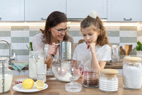 Mother and child preparing bakery together in home kitchen