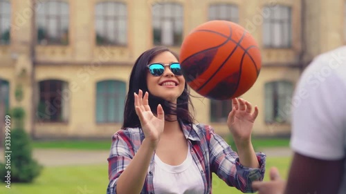 African american college student playing throwing bsketball ball to a classmate girl while they have free time in between lectures. Young people enjoy their free off studdyies time. photo