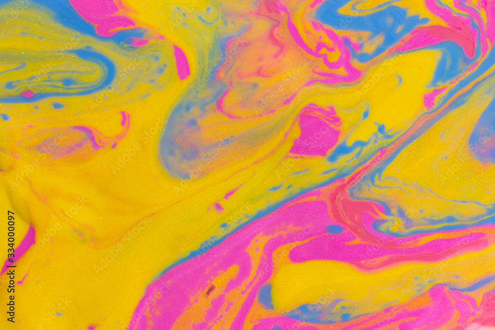 Abstract background of mixed shades of nail polish with a marble pattern. Liquid colorful paint background creative watercolor neon pink, blue, yellow Abstract background of mixed shades of nail polish with a marble pattern. Liquid colorful paint background creative watercolor neon pink, blue, yellow