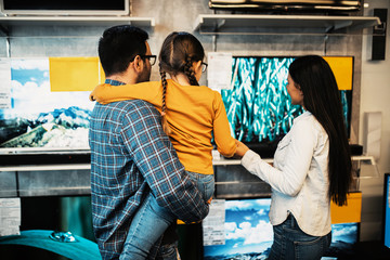 Happy family buying TV in store.