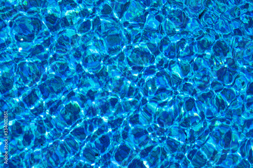 Blue background with lots of light spots. Sun glare in the pool 