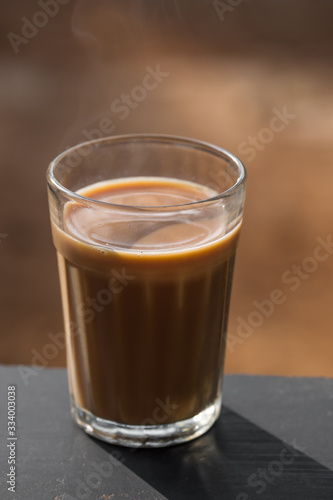 Faceted glass Indian masala tea on a wooden board