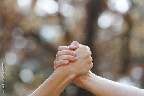 Schilderij op canvas two people shaking hands isolated on a natural background in the park