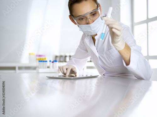 Female laboratory assistant analyzing test tube with blue liquid. Medicine  health care and researching concept