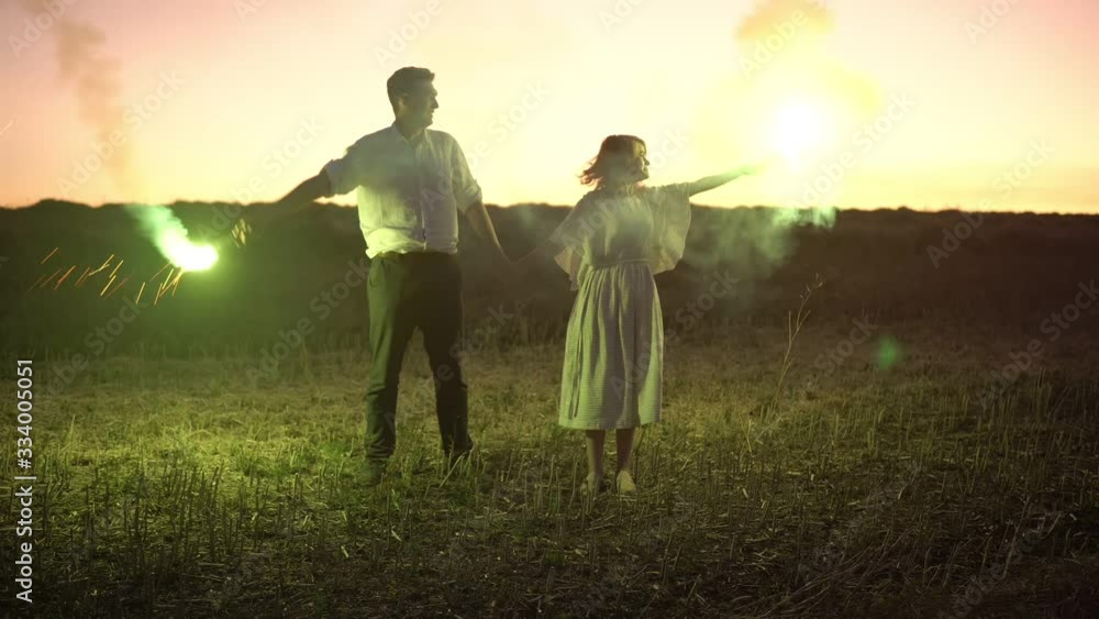 Slow motion of couple in love put smoke candles in the air. Man and woman with color hair holding hands. They lift the green smoke in the air ant put it down. Slow motion of couple in love put smoke candles in the air. Man and woman with color hair holding hands. They lift the green smoke in the air ant put it down.