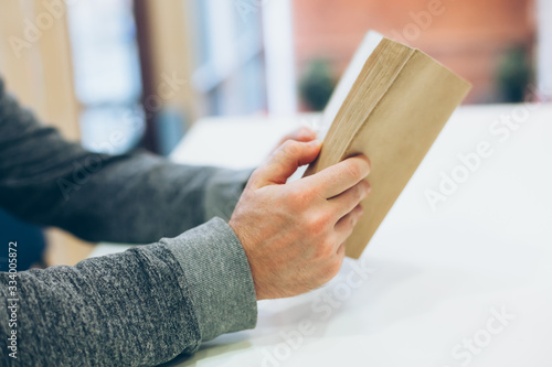 Young man reading open old paper book © dvoevnore