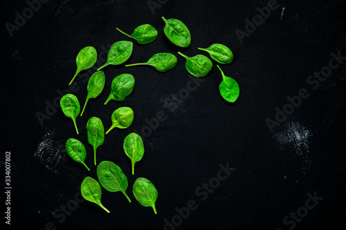 Fresh green baby spinach leaves on abstract black background © boomeart