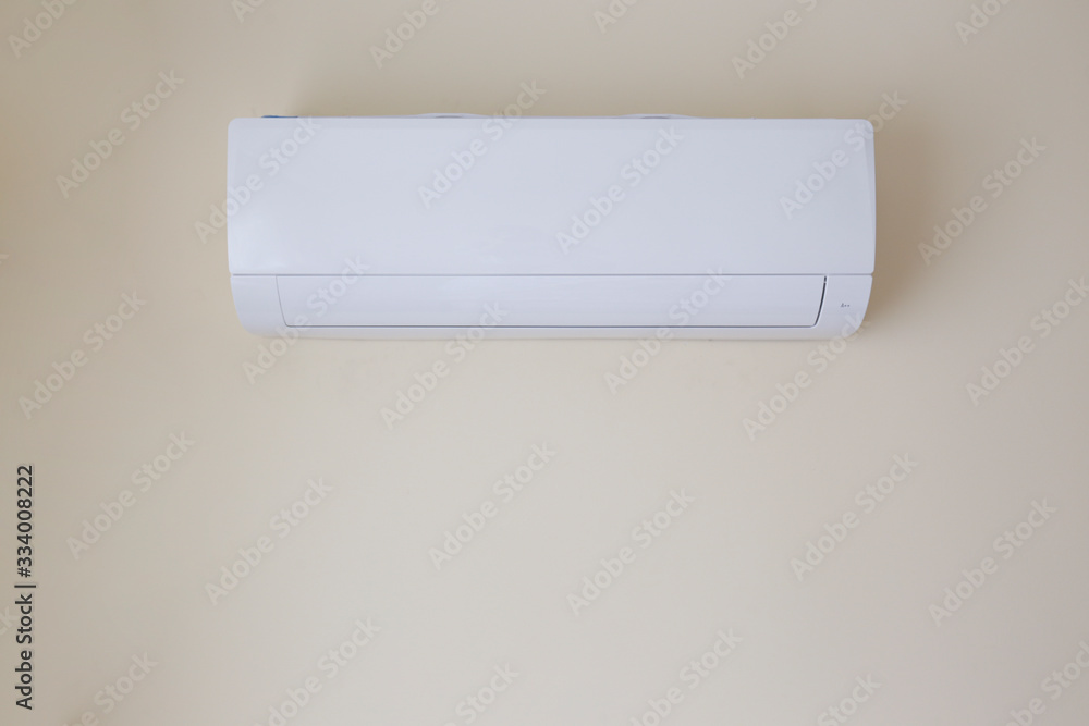 Close up shot of newly installed white air conditioner. Turned off AC hanging on the pastel color wall with a lot of copy space for text. Background. Close up shot of newly installed white air conditioner. Turned off AC hanging on the pastel color wall with a lot of copy space for text. Background.