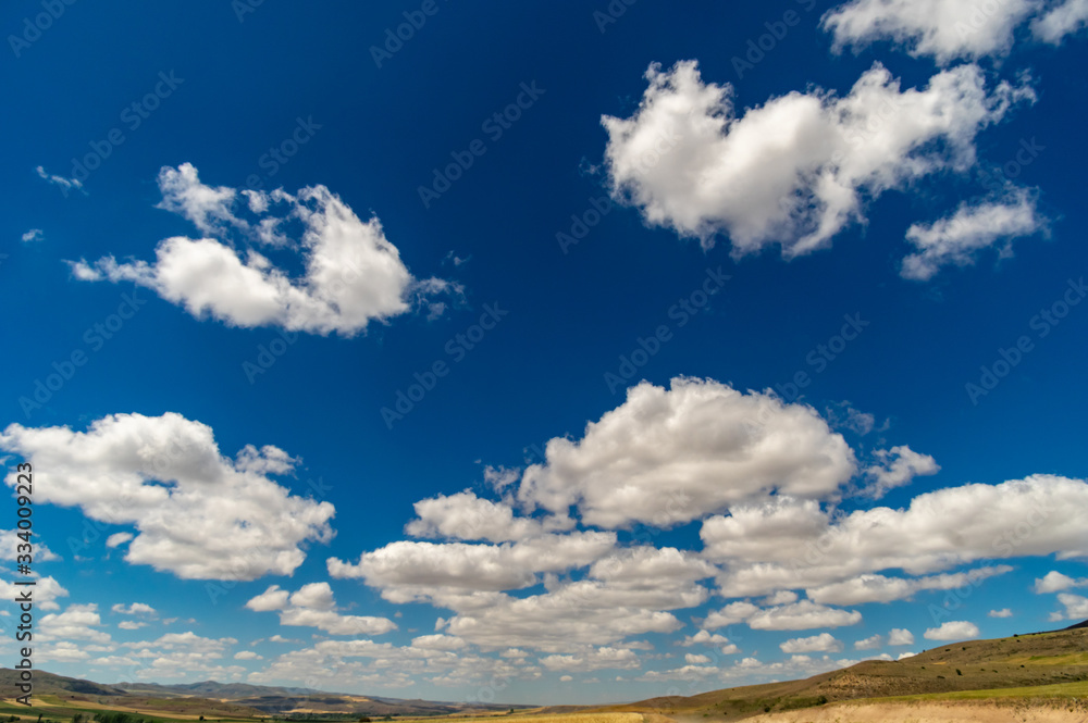 Blue clear sky with clouds and field