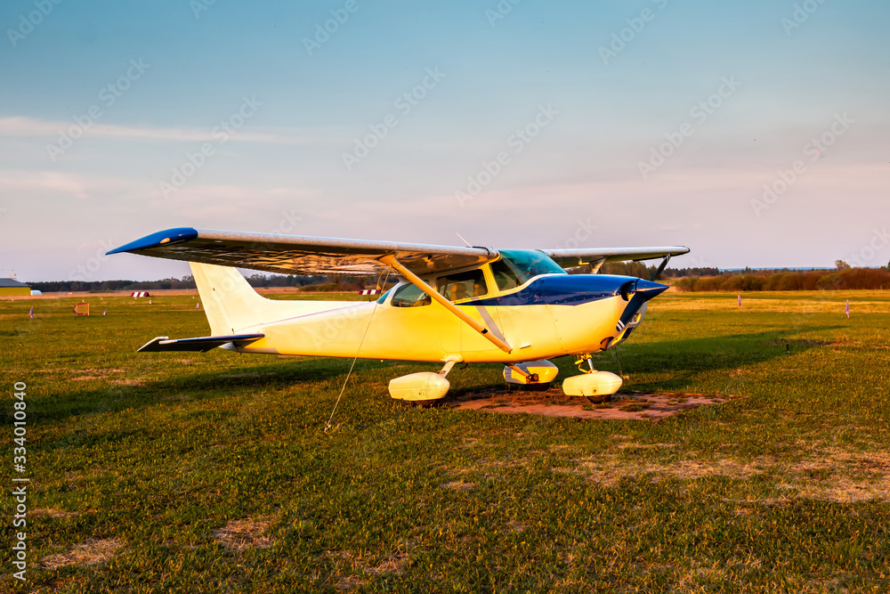 Small private airplane on the airfield in the evening light Small private airplane on the airfield in the evening light