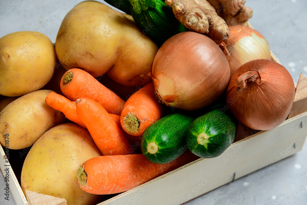 Delivery fresh organic vegetables home. product delivery service. Eco potatoes, carrots, zucchini, onions and ginger in a wooden box. takeaway food in the covid-19 quarantine Delivery fresh organic vegetables home. product delivery service. Eco potatoes, carrots, zucchini, onions and ginger in a wooden box. takeaway food in the covid-19 quarantine