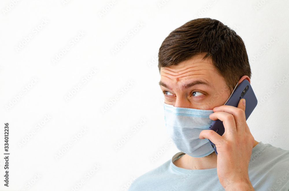 Coronavirus. Quarantine. A man solves work issues remotely. In the mask. Coronavirus. Quarantine. A man solves work issues remotely. In the mask.