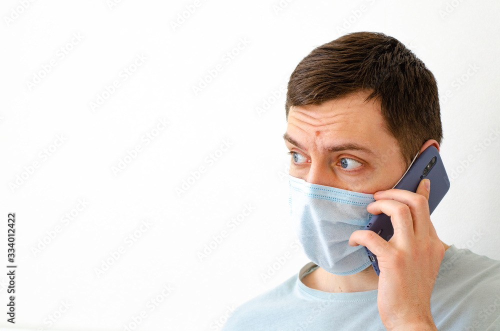 Coronavirus. Quarantine. A man solves work issues remotely. In the mask. Coronavirus. Quarantine. A man solves work issues remotely. In the mask.