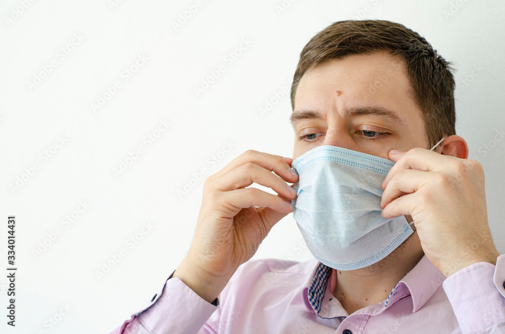 Coronavirus. Quarantine. A man in a shirt puts on a mask. Virus protection. Coronavirus. Quarantine. A man in a shirt puts on a mask. Virus protection.