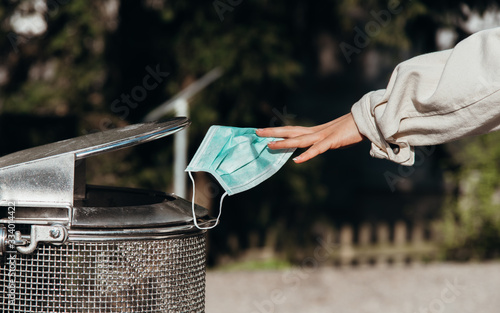 person throws a protective mask into the trash can - .end of covid-19 corona crisis concept picture