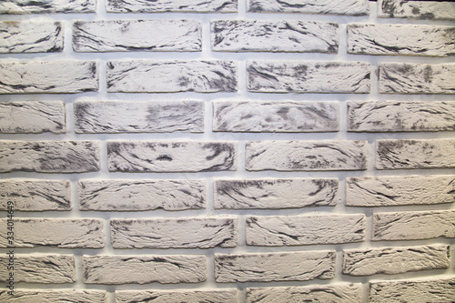 The background is made of artificial stone, white and black, with a rectangular shape in the form of a brick wall. Backgrounds, textures, and design.