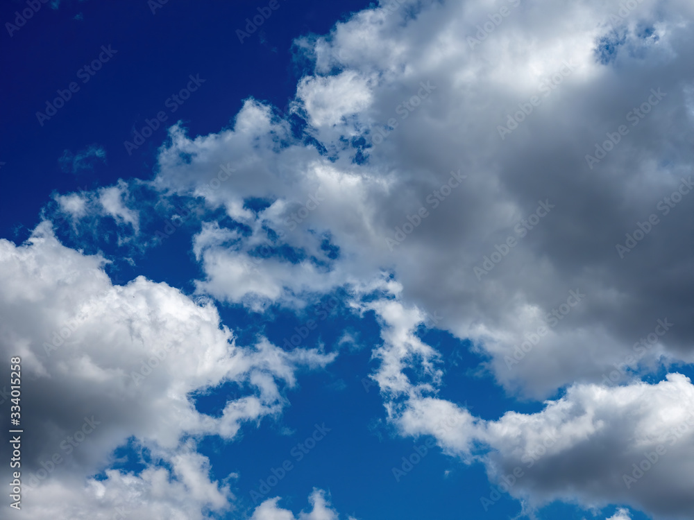 Obraz premium white puffy clouds in a bright blue sky