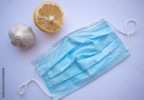 Protective mask, garlic and lemon on a white background