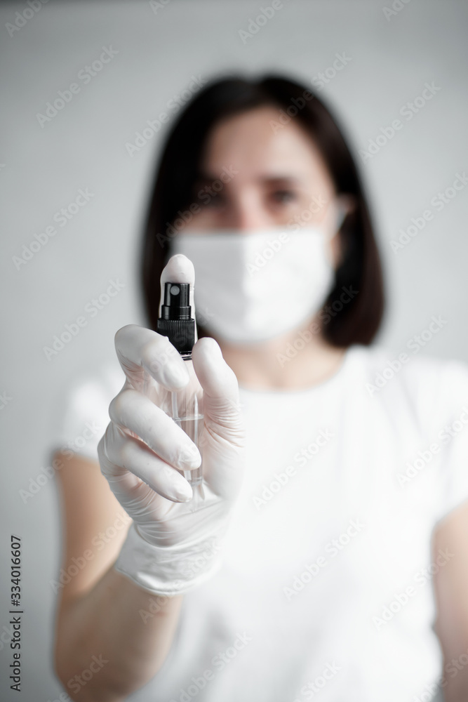 Women wearing protection face mask and gloves hold sanitizer against coronavirus. White clothes and gloves. Sanitizer Women wearing protection face mask and gloves hold sanitizer against coronavirus. White clothes and gloves. Sanitizer