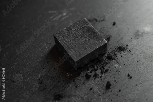 Fototapeta Naklejka Na Ścianę i Meble -  Black carbon charcoal soap on a black granit background 