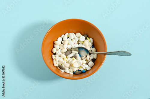 Medication with a spoon. Plate with medicines on a blue background. photo