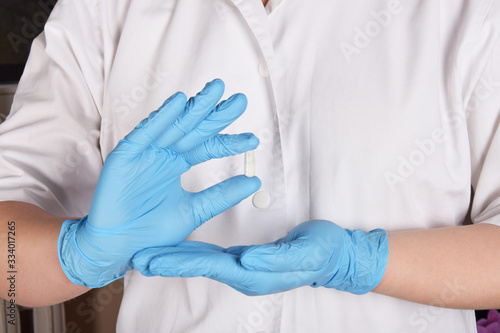 tablets in the hands of a nurse in blue rubber gloves