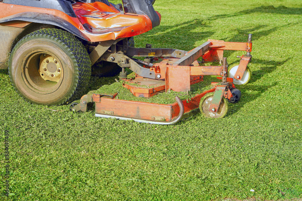 Fototapeta premium Lawn Care. Riding Mower. Grass. Machine mower on a background of green lawn.