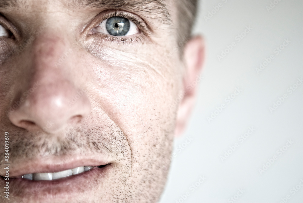 Detail close-up of mid-adult Caucasian man with wrinkles and stubble next to blank copy space Detail close-up of mid-adult Caucasian man with wrinkles and stubble next to blank copy space