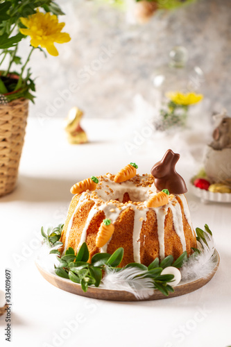 Easter lemon cake with icing and easter decoration. Easter gugelhupf cake with marzipan carrots and chocolate easter bunny