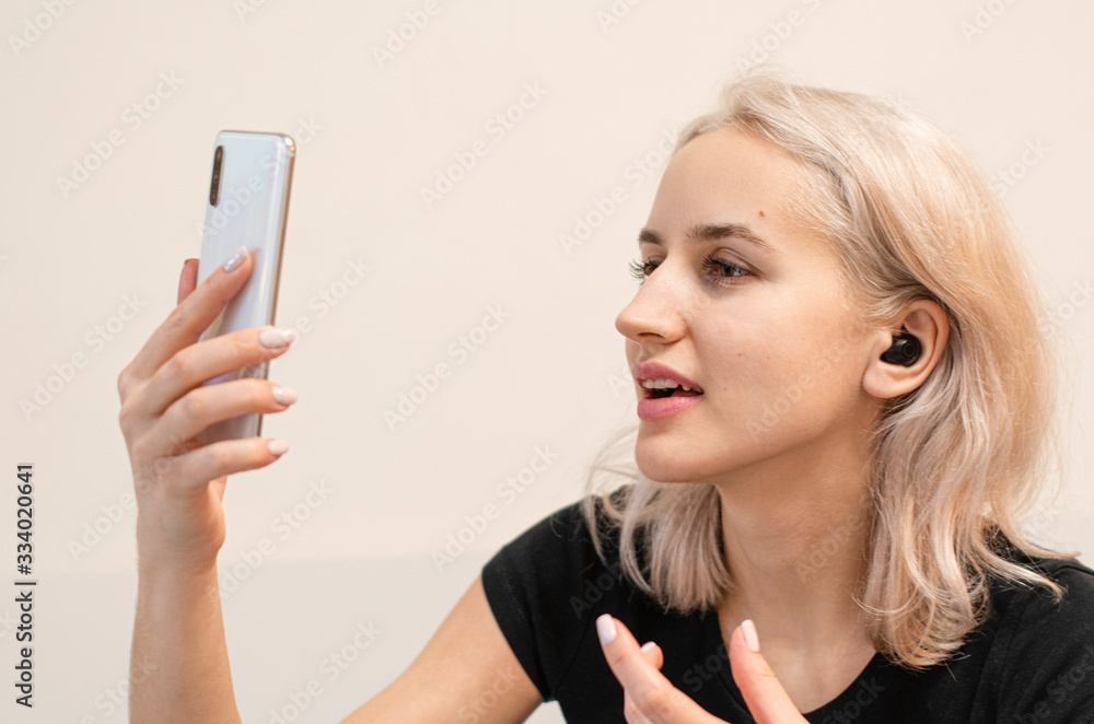 Girl communicates by video call. Wireless headphones. Modern technologies. Girl communicates by video call. Wireless headphones. Modern technologies.