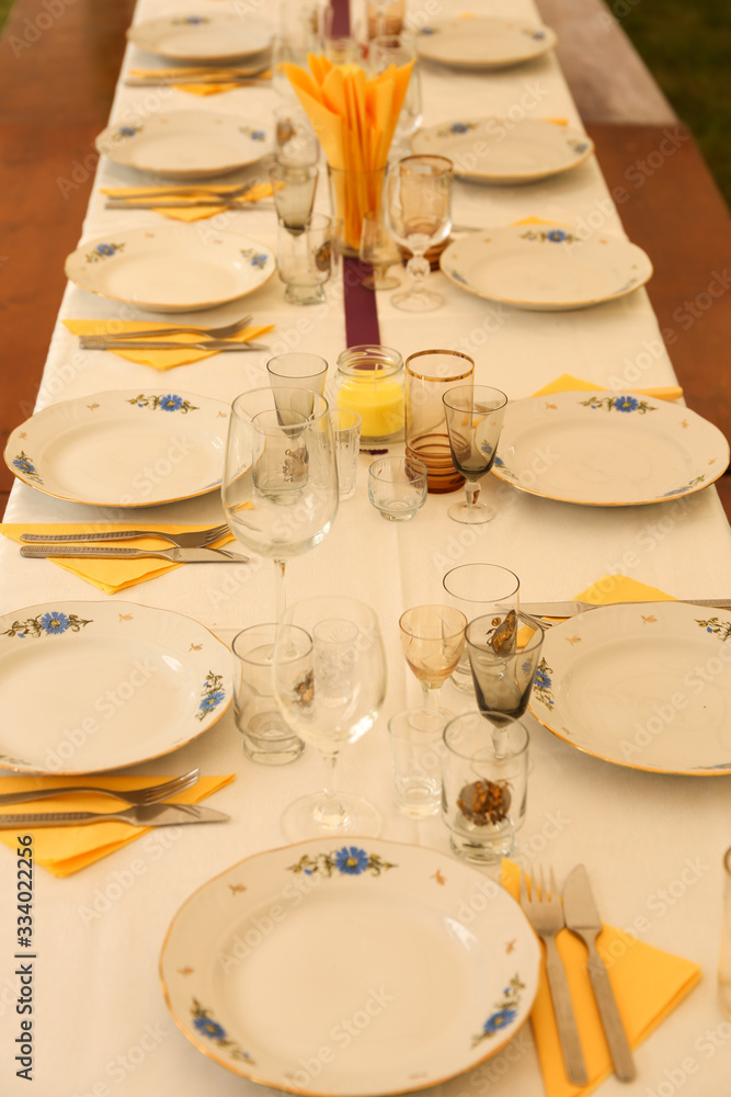 Party dinner table with plates, knives, forks, napkins and glases