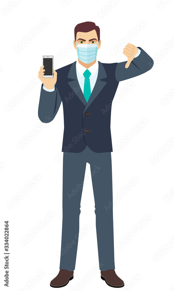 Angry Businessman with medical mask holding a mobile phone and showing thumb down gesture as rejection symbol. Full length portrait of Businessman in a flat style. Angry Businessman with medical mask holding a mobile phone and showing thumb down gesture as rejection symbol. Full length portrait of Businessman in a flat style.