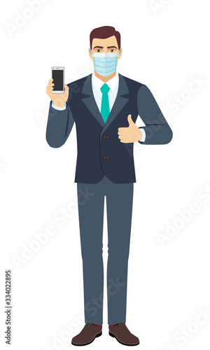Businessman with medical mask holding mobile phone and shows thumb up. Full length portrait of Businessman in a flat style.