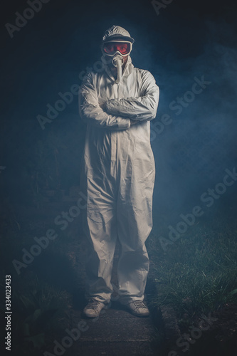 Man dressed up for deadly corona virus or covid 19. Man joking out of a serious pandemic desease. Night photo of a scary man trying to fight corona.