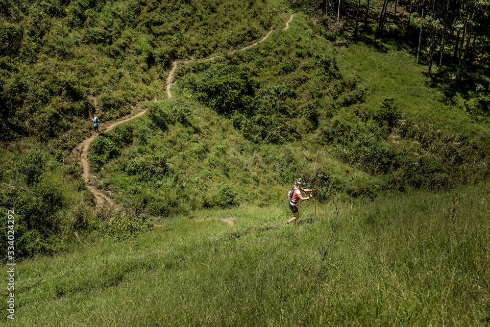 Imagem de vale montanhoso, mostrando as trilhas por onde atletas de trail run sobem, até o topo. Em São Bento do Sapucaí, SP, Brasil.