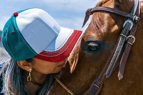 Detalhe de tratadora quase beijando o seu cavalo de cor alazão, da raça quarto de milha. photo