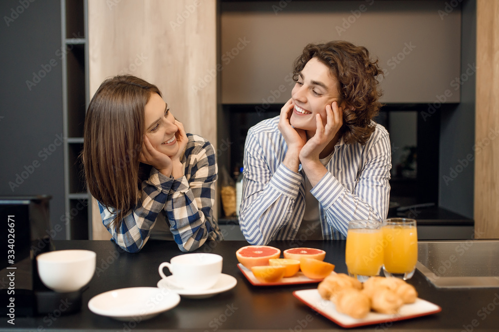 Cute young married couple enjoying their early morning breakfast together Cute young married couple enjoying their early morning breakfast together