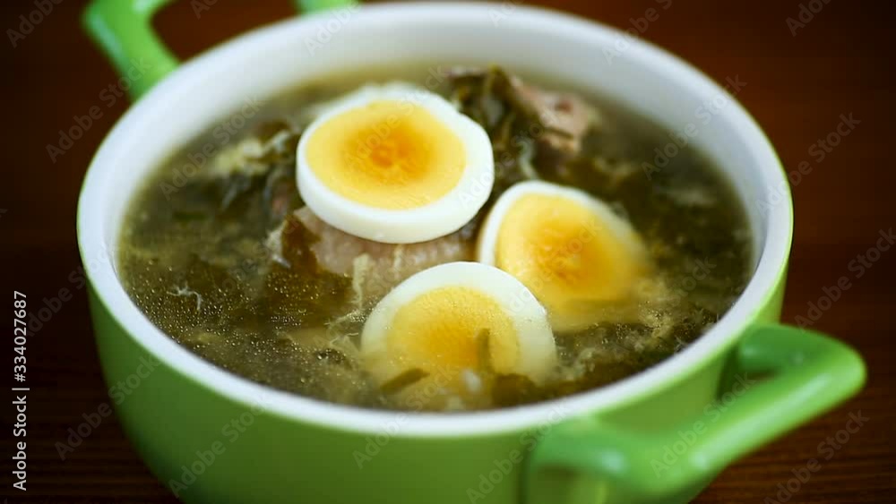 fresh spring organic soup with green sorrel and egg in a plate on a wooden table fresh spring organic soup with green sorrel and egg in a plate on a wooden table