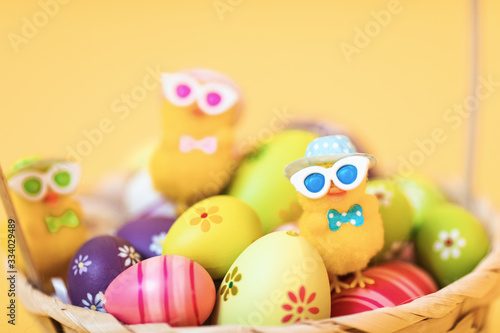 Easter chick and painted Easter eggs isolated on yellow background © Shopping King Louie