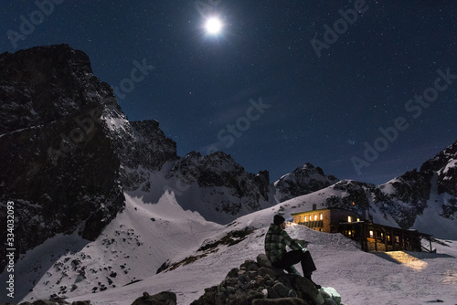 Men sitting in the mountains under the night sky