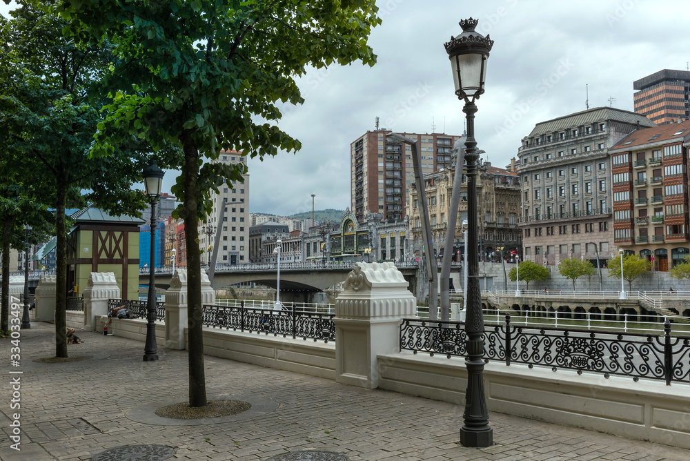 Promenade on the Nervion river with the Arenal Bridge and the Bilbao-Abando train station
